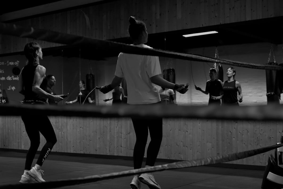 Groep springt touw voor de spiegel tijdens bokstraining bij Usaha Boksen in Tilburg